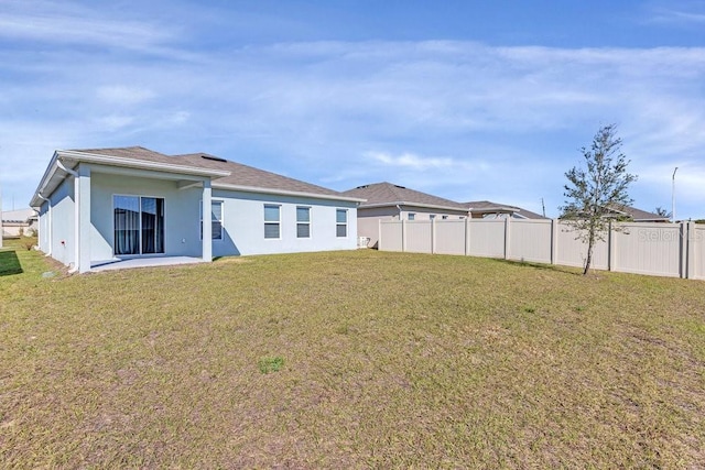 rear view of property featuring a yard