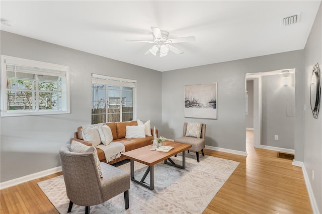 living room featuring ceiling fan, a healthy amount of sunlight, and light wood-type flooring