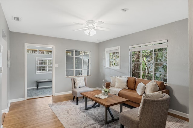 living room with wood-type flooring, a wealth of natural light, and ceiling fan