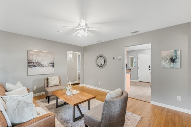 living room featuring ceiling fan and light hardwood / wood-style floors