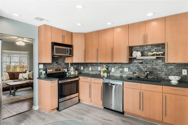 kitchen featuring sink, tasteful backsplash, appliances with stainless steel finishes, ceiling fan, and light hardwood / wood-style floors