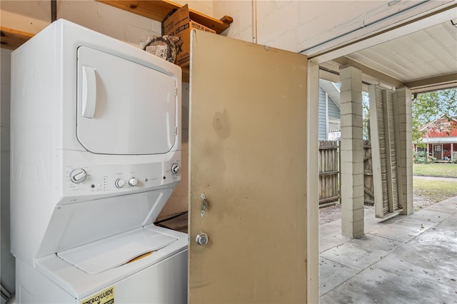 washroom with stacked washing maching and dryer