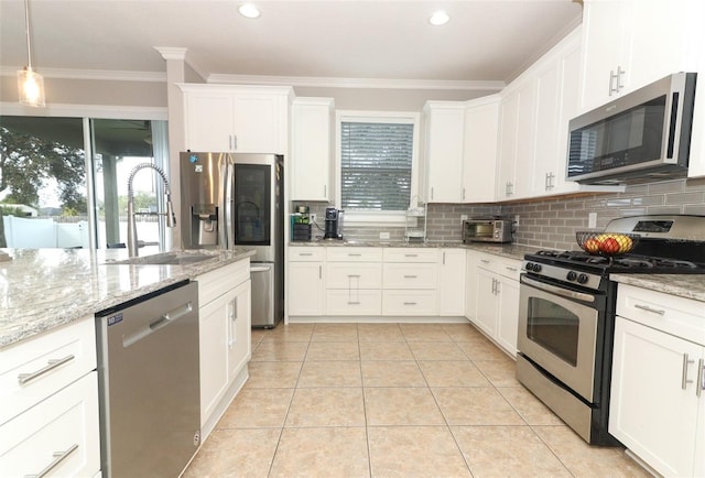 kitchen with sink, light stone counters, hanging light fixtures, stainless steel appliances, and white cabinets