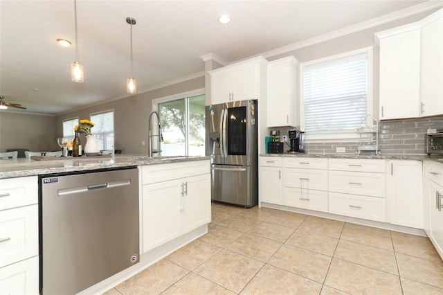 kitchen featuring white cabinetry, ornamental molding, appliances with stainless steel finishes, and hanging light fixtures