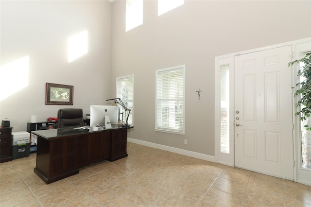 tiled home office with a high ceiling and a wealth of natural light