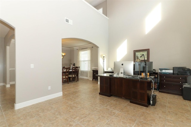 office space with a high ceiling and light tile patterned floors