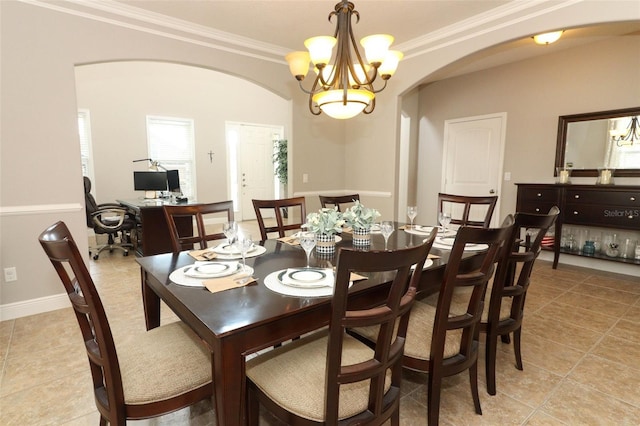 dining room featuring crown molding, light tile patterned flooring, and an inviting chandelier