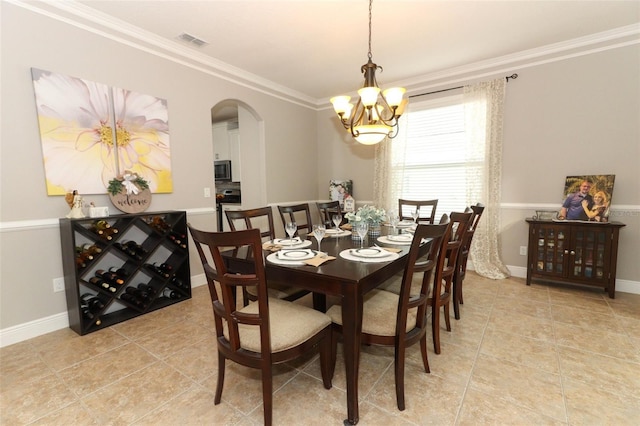 tiled dining room with ornamental molding and an inviting chandelier