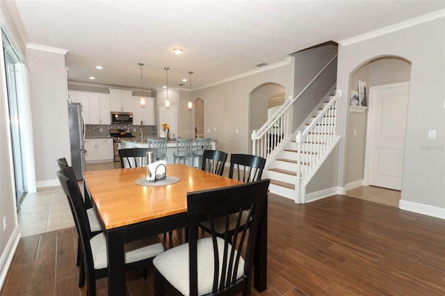 dining room with crown molding and hardwood / wood-style floors