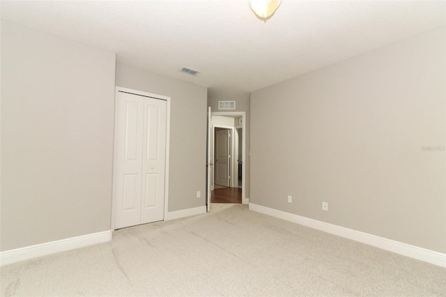 unfurnished bedroom featuring carpet floors, a textured ceiling, and a closet