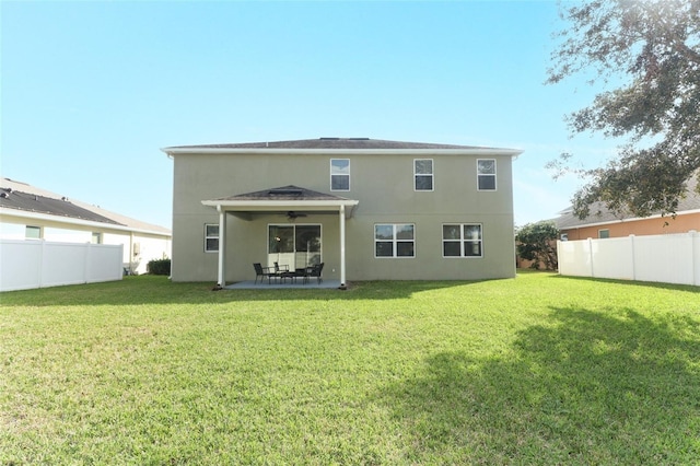 back of property featuring ceiling fan, a yard, and a patio