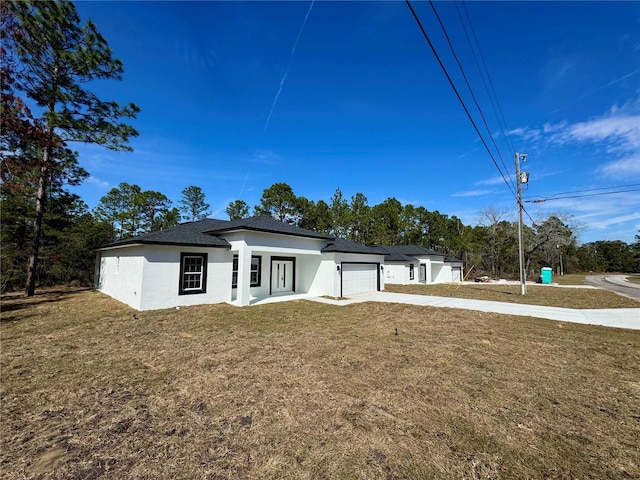 view of front of home featuring a garage and a front lawn