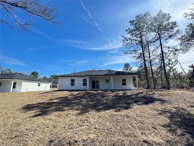 rear view of house featuring a yard