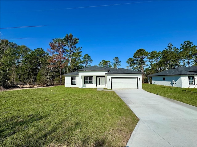 view of front of property featuring driveway, a garage, a front lawn, and stucco siding