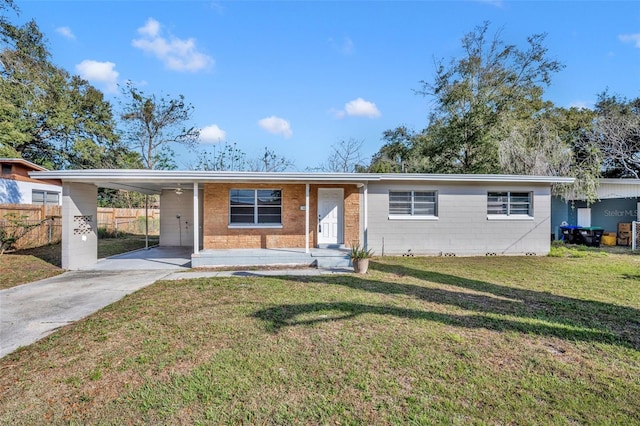 ranch-style home featuring a carport, a front yard, driveway, and fence