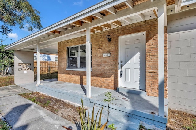 property entrance with brick siding and fence