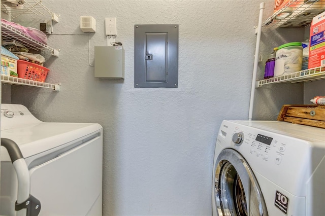 clothes washing area with washer and dryer and electric panel