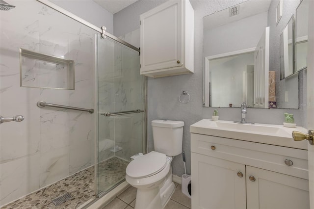 bathroom featuring tile patterned flooring, an enclosed shower, vanity, and toilet