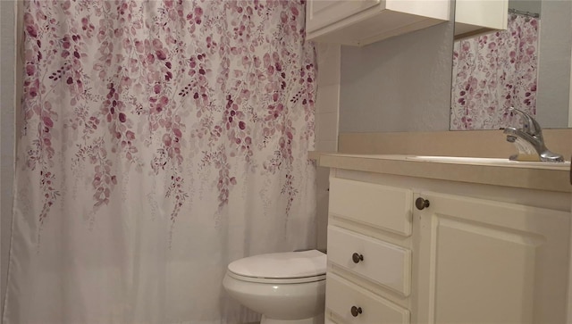 bathroom featuring a shower with shower curtain, vanity, and toilet