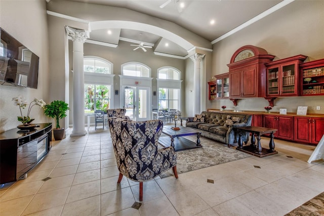 living room with high vaulted ceiling, light tile patterned floors, ornate columns, and ceiling fan