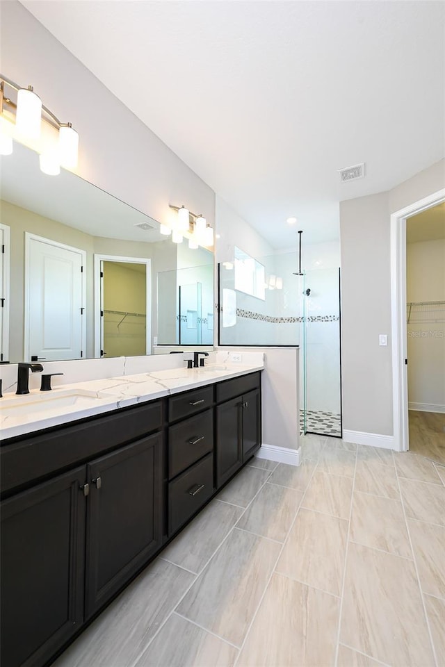 full bath featuring double vanity, visible vents, a sink, and walk in shower