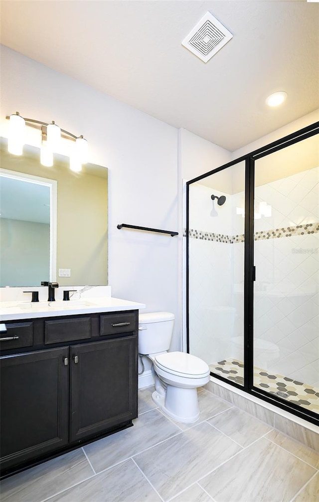 full bathroom featuring toilet, a shower stall, visible vents, and vanity