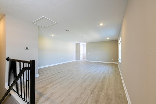 empty room with recessed lighting, visible vents, baseboards, light wood finished floors, and attic access