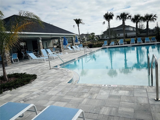 pool featuring fence and a patio