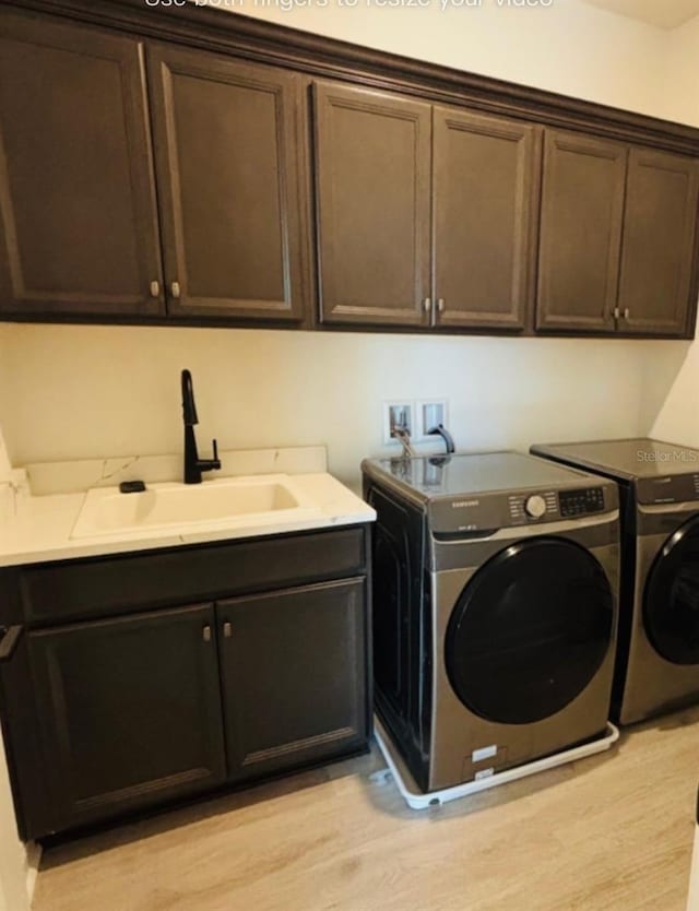 4425 Lions Gate Ave, Clermont, FL 34711 - washroom featuring cabinet space, washing machine and dryer, and light wood-type flooring