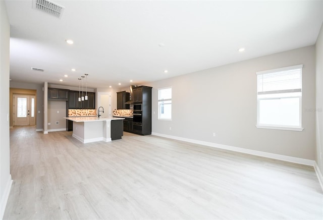 4425 Lions Gate Ave, Clermont, FL 34711 - kitchen with open floor plan, recessed lighting, light countertops, a kitchen island with sink, and light wood-type flooring