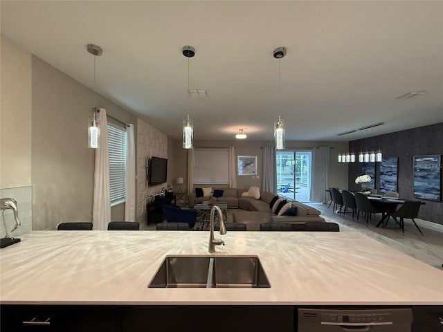 kitchen featuring hanging light fixtures, dishwasher, rail lighting, and sink