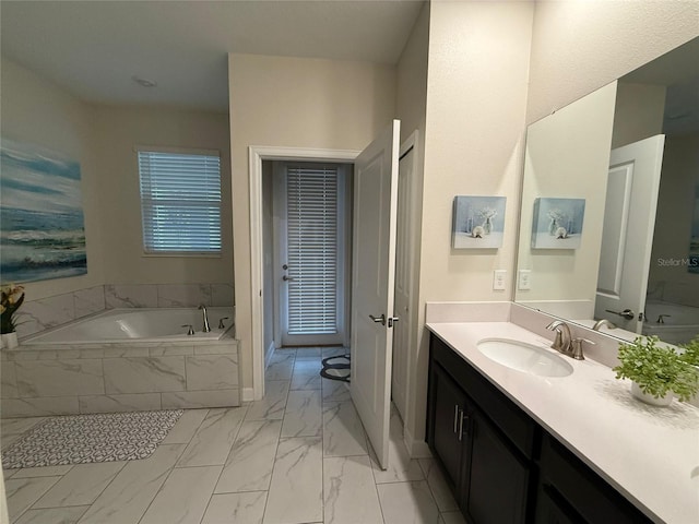 bathroom featuring vanity and a relaxing tiled tub