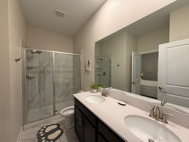 bathroom with vanity, a shower with door, and toilet