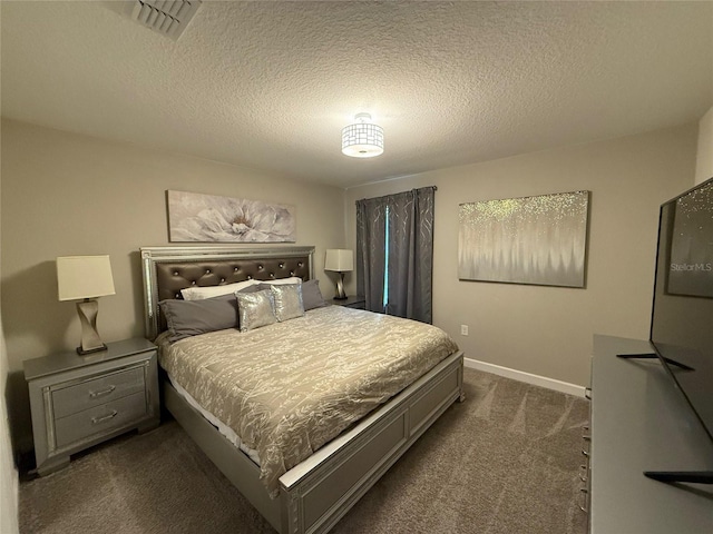 bedroom with dark colored carpet and a textured ceiling