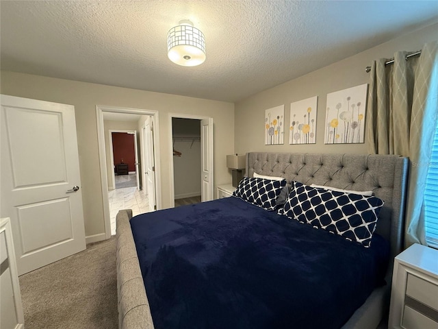 bedroom featuring a closet, light carpet, and a textured ceiling