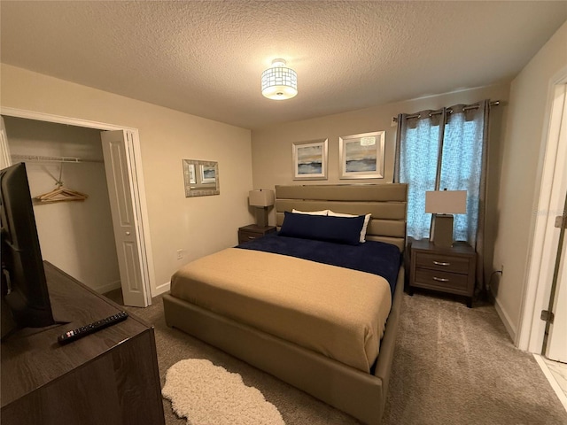 bedroom with a closet, carpet floors, and a textured ceiling