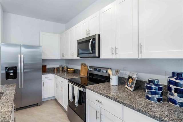 kitchen with stainless steel appliances, white cabinets, and dark stone counters