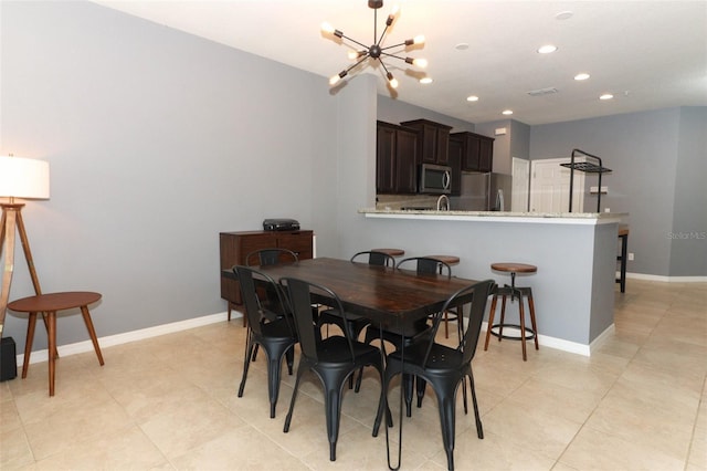 dining space with light tile patterned floors and a chandelier