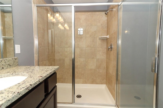 bathroom with vanity and a shower with door