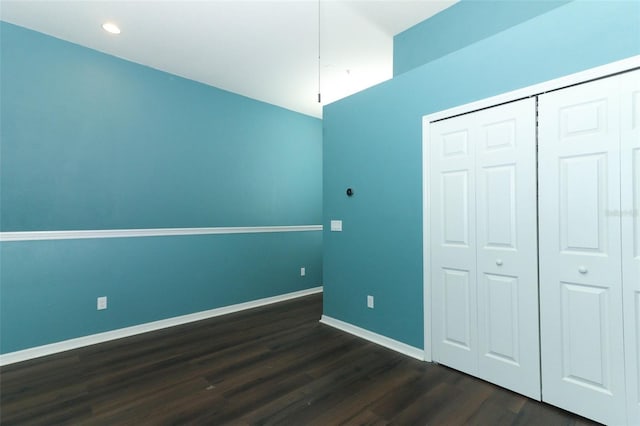 unfurnished bedroom with dark wood-type flooring and a closet