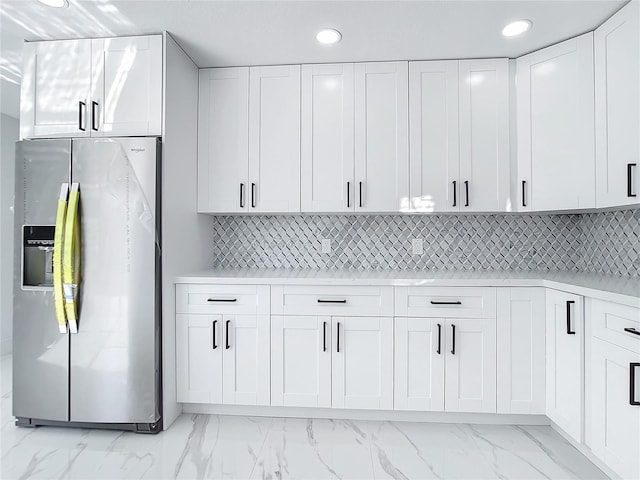 kitchen with white cabinetry, stainless steel fridge, and decorative backsplash