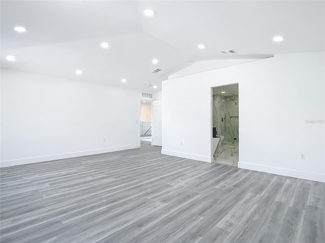 spare room with hardwood / wood-style floors and lofted ceiling