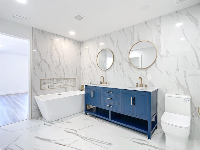 bathroom featuring a tub to relax in, toilet, and vanity