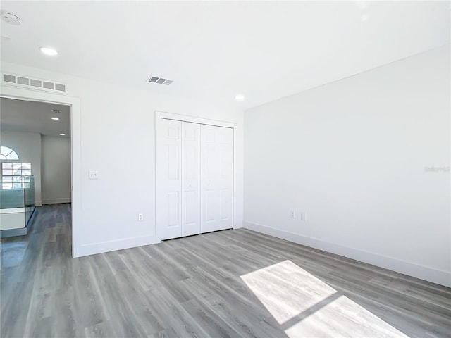 unfurnished bedroom featuring light hardwood / wood-style floors and a closet