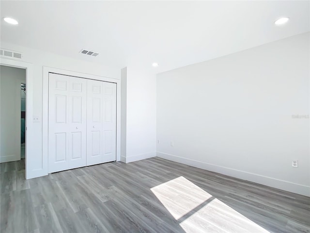 unfurnished bedroom with hardwood / wood-style flooring and a closet