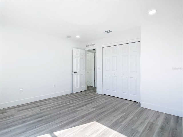 unfurnished bedroom with light hardwood / wood-style floors and a closet