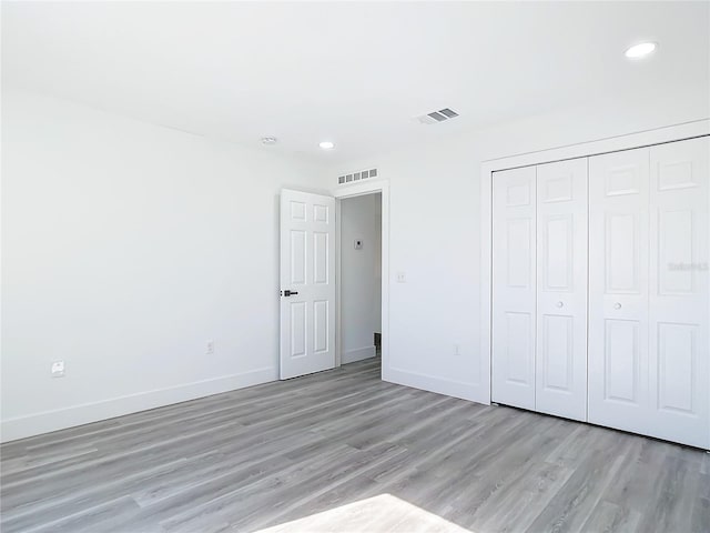 unfurnished bedroom featuring light wood-type flooring and a closet