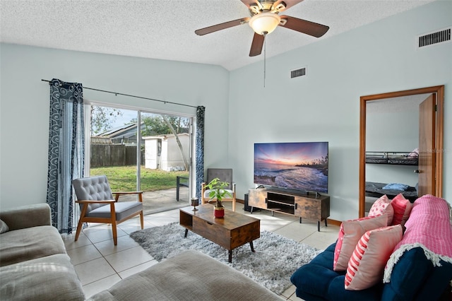 tiled living room with ceiling fan, lofted ceiling, and a textured ceiling