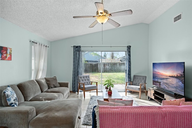 tiled living room featuring lofted ceiling, a textured ceiling, and ceiling fan