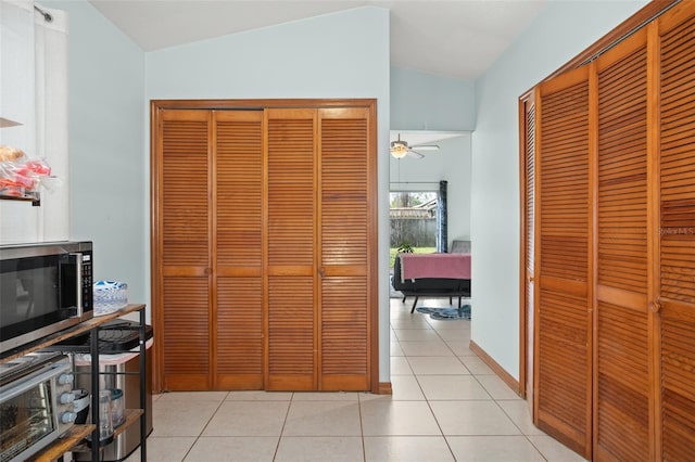 hallway with lofted ceiling and light tile patterned floors